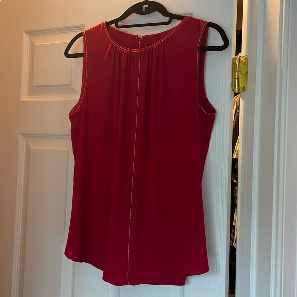 Red sleeveless work blouse with silver beading and shirt tail hem